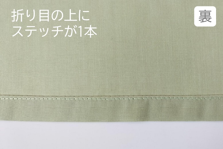 裏から：裾端を２回折り曲げた上をステッチが走っています。